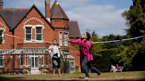 Children playing badminton in front of the house in the garden at Sunnycroft, Shropshire